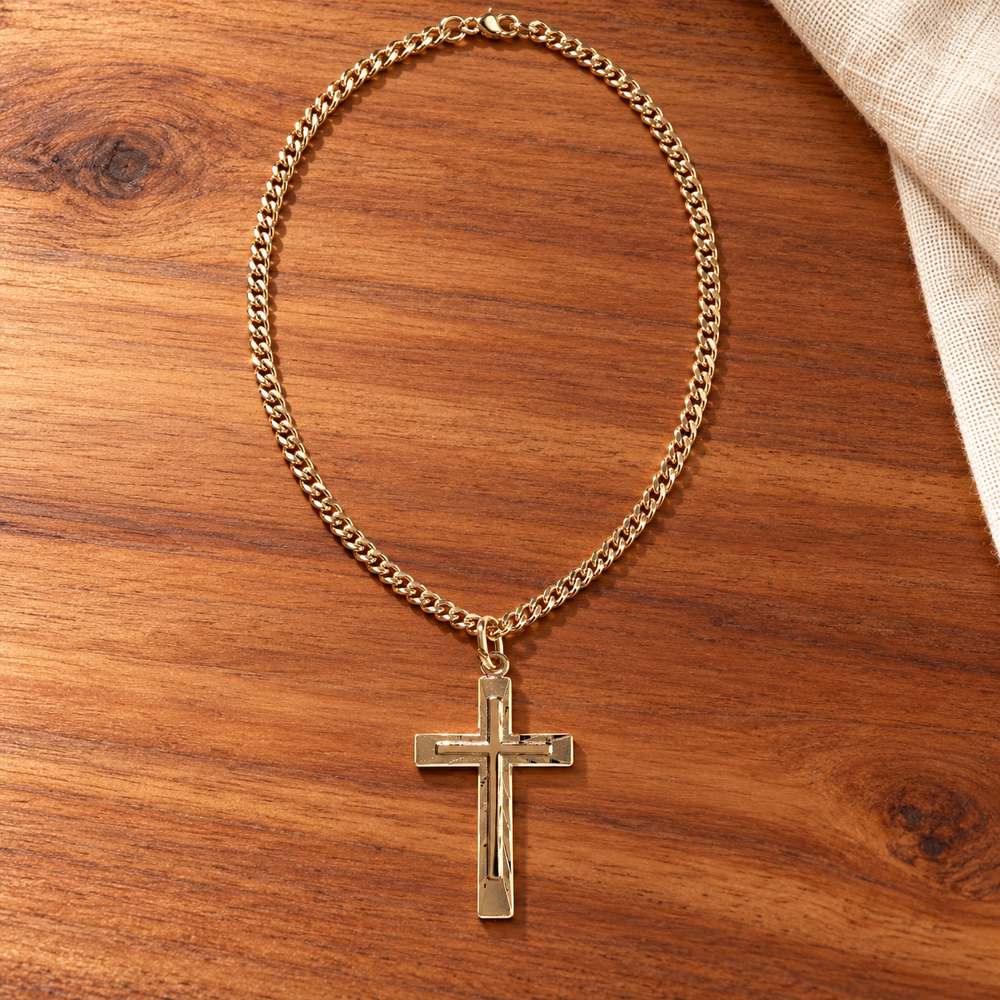 Dimensional gold-plated cross necklace on warm cedar tabletop